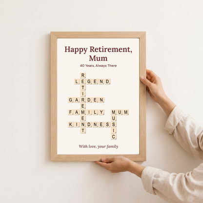 Personalised retirement crossword poster in an oak frame held against a wall — "Happy Retirement, Mum" design, 40 years